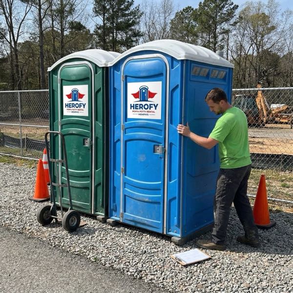 Technician servicing porta potties at construction site